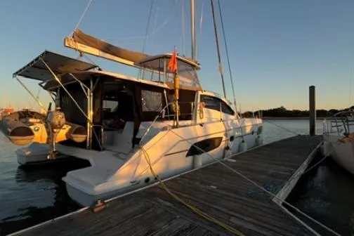 Slide: The Image of 2014 Leopard 44 catamaran docked at sunset, showcasing sleek design and spacious deck. - 4