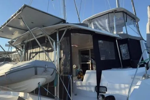 Slide: The Image of 2014 Leopard 44 catamaran with dinghy, featuring covered cockpit and modern design. - 5