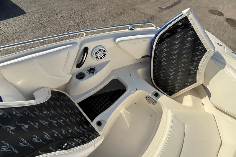 Slide: The Image of 2011 Monterey 264 FS boat interior with open storage compartments and cup holders. - 11