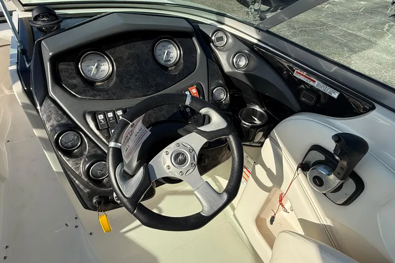 Slide: The Image of Steering console of a 2011 Moneterey 264 FS boat with gauges and controls. - 13