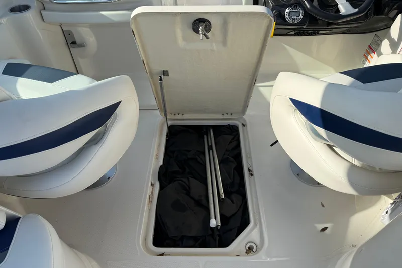 Slide: The Image of Open storage compartment on 2011 Monterey 264 FS boat with white and blue seating. - 16