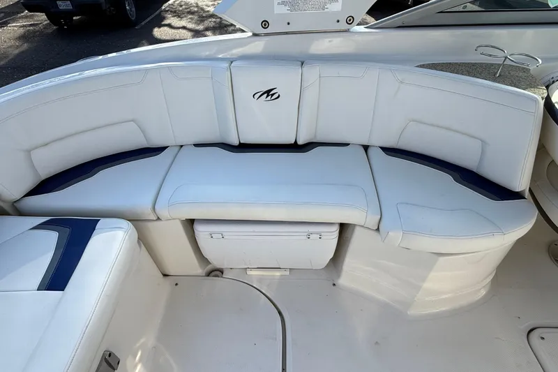 Slide: The Image of 2011 Monterey 264 FS boat with white cushioned seating and storage compartment. - 19