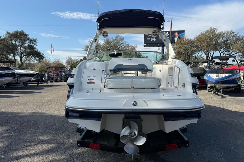 Slide: The Image of 2011 Monterey 264 FS boat, rear view, parked outdoors with other boats nearby. - 4