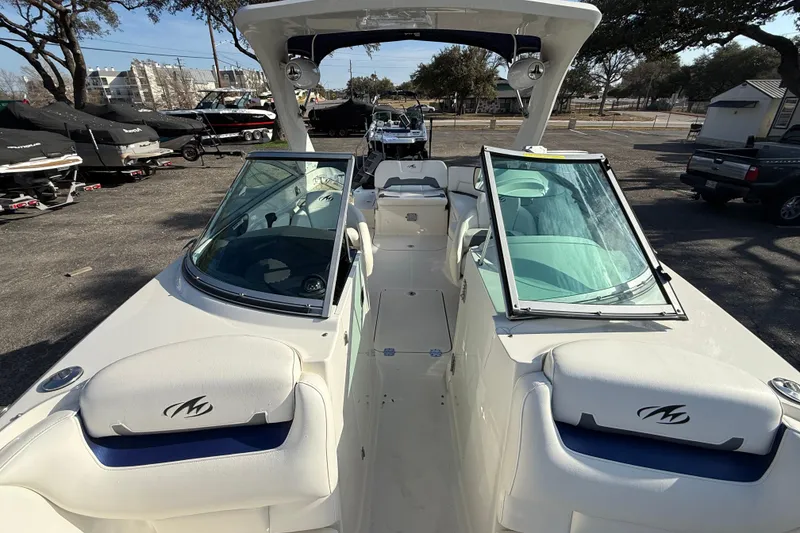 Slide: The Image of 2011 Monterey 264 FS boat with open windshield, parked outdoors. - 9