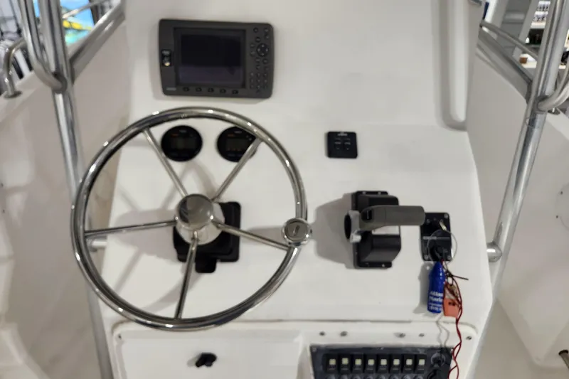 Slide: The Image of 2004 Edgewater 225CC boat console with steering wheel, gauges, and controls. - 11