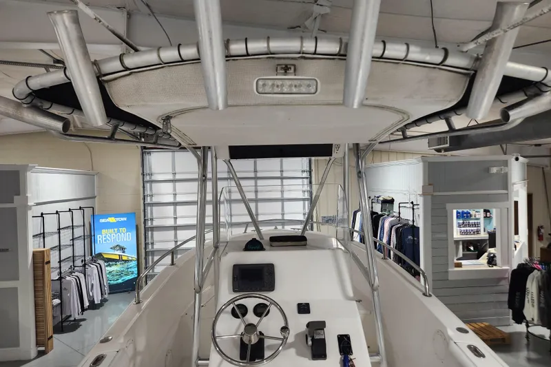 Slide: The Image of 2004 Edgewater 225CC boat interior with steering wheel and controls in showroom. - 14