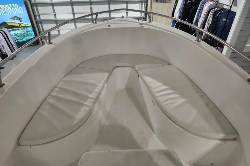 Slide: The Image of 2004 Edgewater 225CC boat interior with cushioned seating in a showroom. - 19
