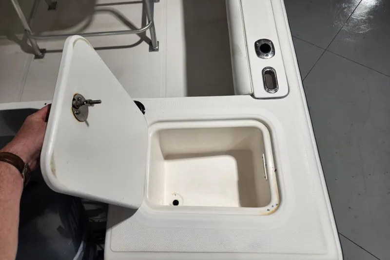 Slide: The Image of Open storage compartment on a 2004 Edgewater 225CC boat, showing interior details. - 23