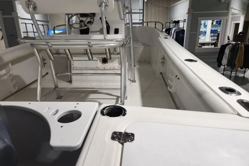 Slide: The Image of 2004 Edgewater 225CC boat interior with seating and rod holders in showroom. - 7