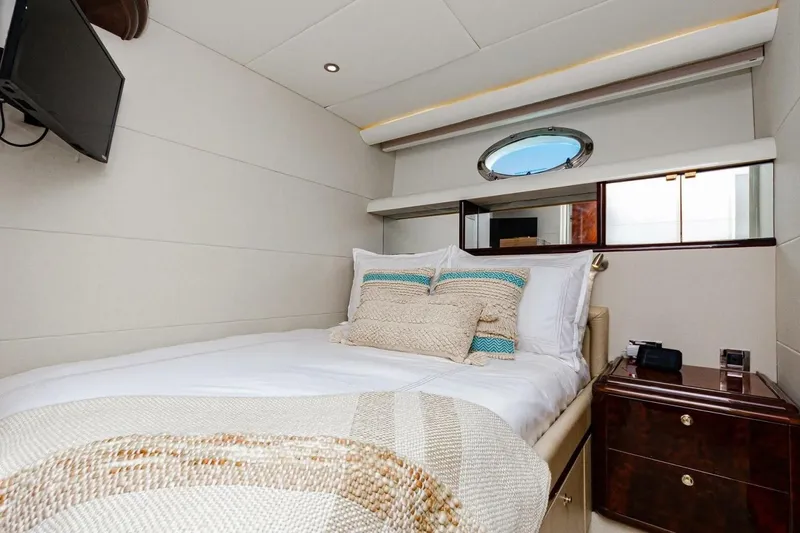 Slide: The Image of Luxurious bedroom interior of 2001 Lazzara 94 Motor Yacht with cozy bedding and porthole window. - 40