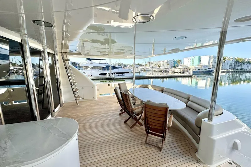 Slide: The Image of Luxurious 2001 Lazzara 94 Motor Yacht deck with seating, table, and marina view. - 55