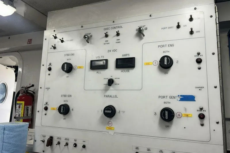 Slide: The Image of Control panel of a 2001 Lazzara 94 Motor Yacht, featuring various switches and gauges. - 64