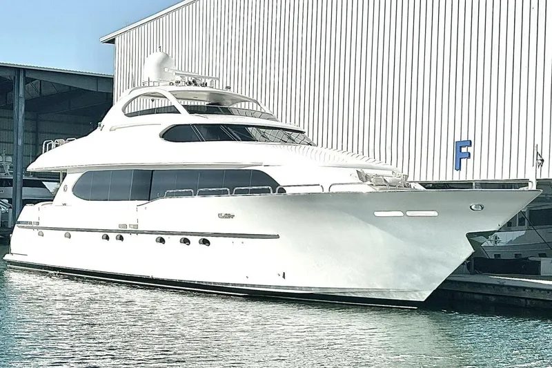 Slide: The Image of 2001 Lazzara 94 Motor Yacht docked near a large warehouse. - 74