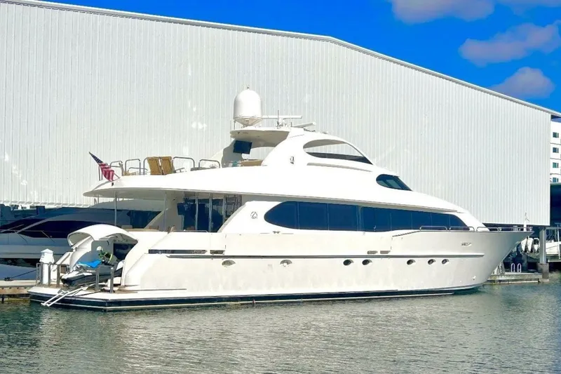 Slide: The Image of 2001 Lazzara 94 Motor Yacht docked by a large warehouse. - 76