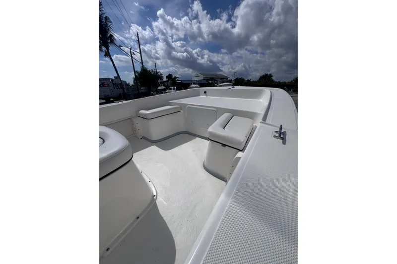 Slide: The Image of 2026 Sundance B20CCR boat interior with white seating under a partly cloudy sky. - 3