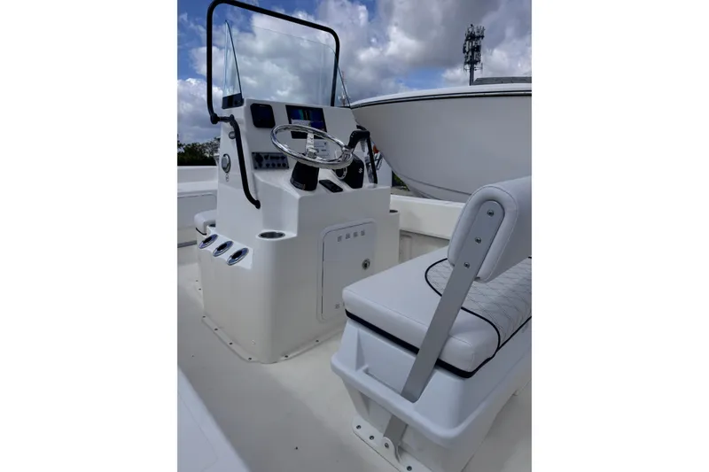 Slide: The Image of 2026 Sundance B20CCR boat interior with steering console and cushioned seating. - 4
