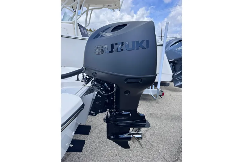 Slide: The Image of Sundance B20CCR 2026 boat with Suzuki outboard motor, parked on a sunny day. - 9