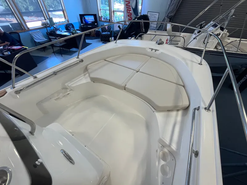 Slide: The Image of The image shows the cockpit of a Boston Whaler 170 Montauk with white cushions and stainless steel railing. - 12