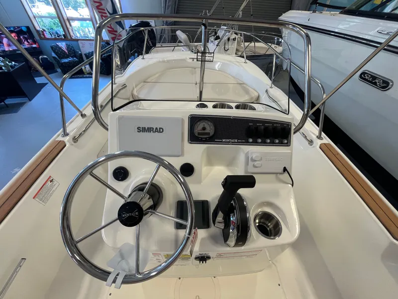 Slide: The Image of The image shows the helm of a Boston Whaler 170 Montauk with steering wheel and instruments. - 9