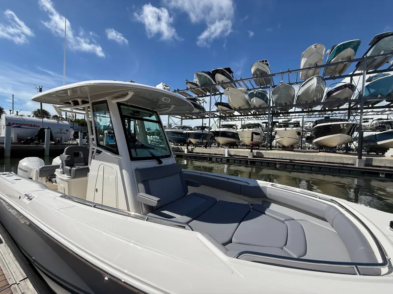 Slide: The Image of A 2027 Boston Whaler 250 Outrage docked at a marina. It features a sleek design and gray upholstery. - 31