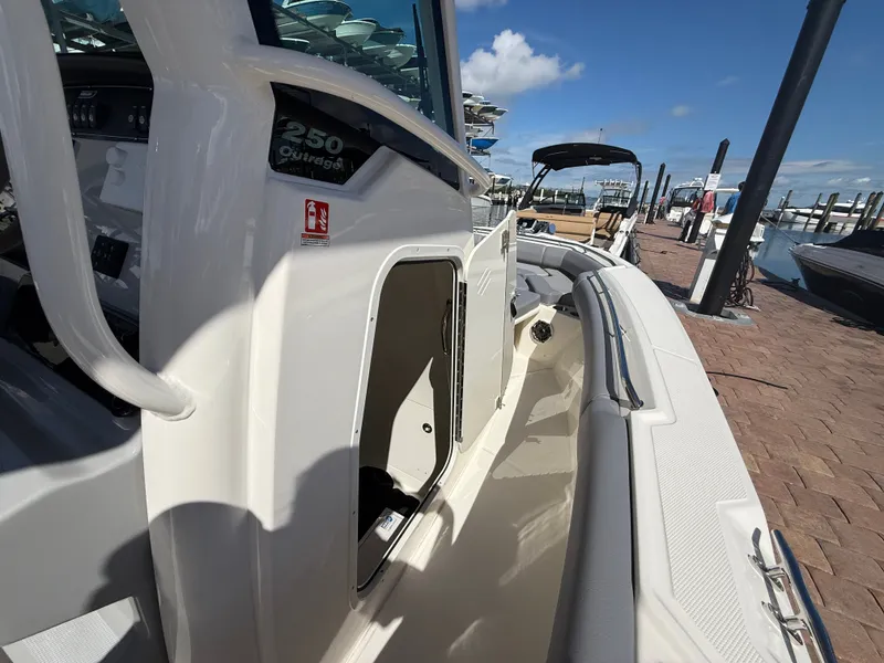 Slide: The Image of 2027 Boston Whaler 250 Outrage at dock with open storage compartment. - 14