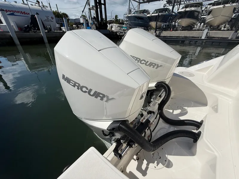 Slide: The Image of Two Mercury outboard engines on a Boston Whaler 250 Outrage, docked at a marina. - 33