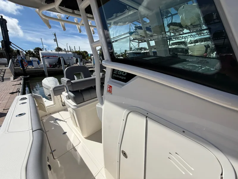 Slide: The Image of The image shows a 2027 Boston Whaler 250 Outrage boat docked at a marina. - 17