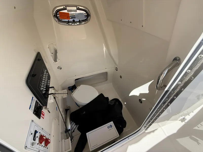 Slide: The Image of Interior of a Boston Whaler 250 Outrage featuring a toilet and control panel. - 15