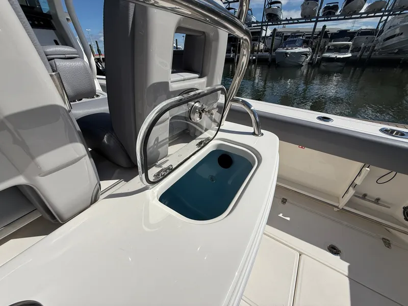 Slide: The Image of The image shows the cockpit of a Boston Whaler 250 Outrage with an open storage compartment. - 24