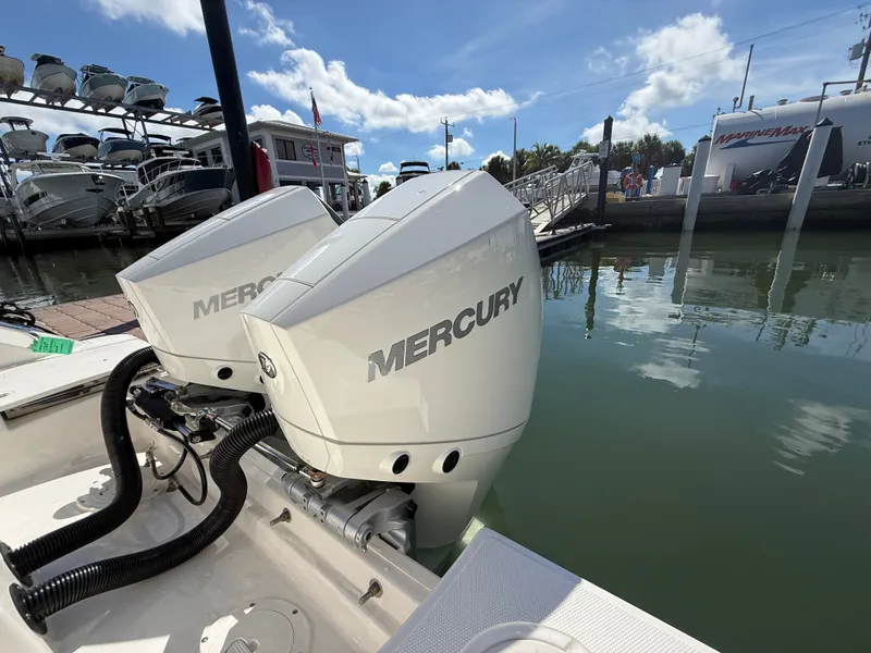 Slide: The Image of Two Mercury outboard engines on a Boston Whaler 250 Outrage, docked at a sunny marina. - 32