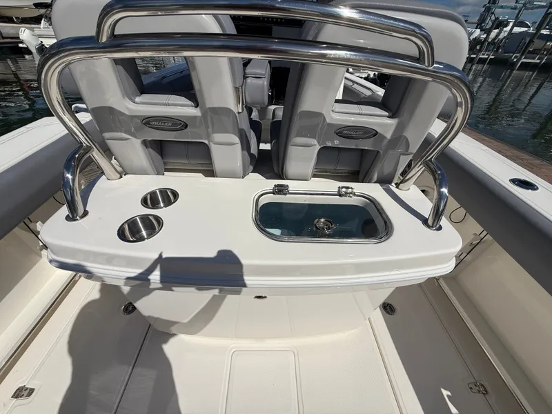 Slide: The Image of The image shows the cockpit of a Boston Whaler 250 Outrage with stainless steel cup holders and a livewell. - 23