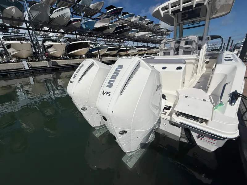 Slide: The Image of A 2027 Boston Whaler 250 Outrage with twin powerful outboard engines docked at a marina. - 34