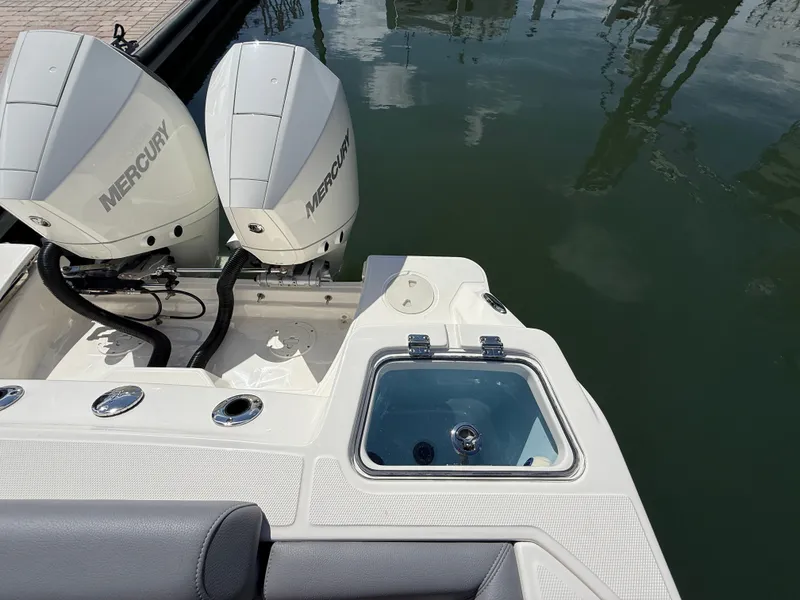 Slide: The Image of The image shows the stern of a Boston Whaler 250 Outrage with twin Mercury engines and a livewell. - 28