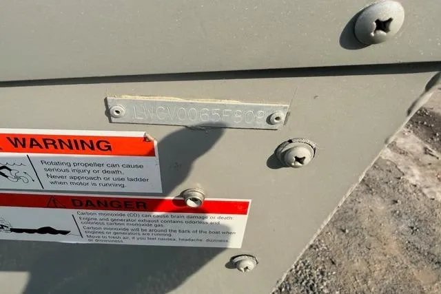 Slide: The Image of 2009 Lowe Fishing Machine 165 with warning labels and serial number plate. - 4