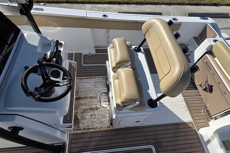Slide: The Image of 2018 Sportsman Open 252 Center Console boat interior with tan seating and steering wheel. - 10