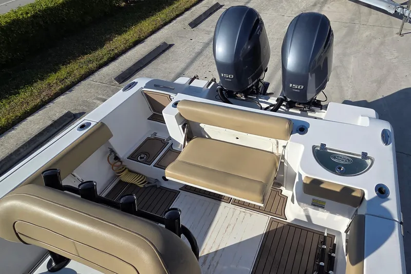 Slide: The Image of 2018 Sportsman Open 252 Center Console boat with dual engines and tan seating. - 12