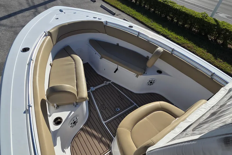 Slide: The Image of 2018 Sportsman Open 252 Center Console boat interior with tan seating and wood-style flooring. - 16