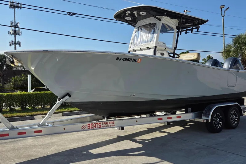 Slide: The Image of 2018 Sportsman Open 252 Center Console boat on trailer, parked outdoors. - 2