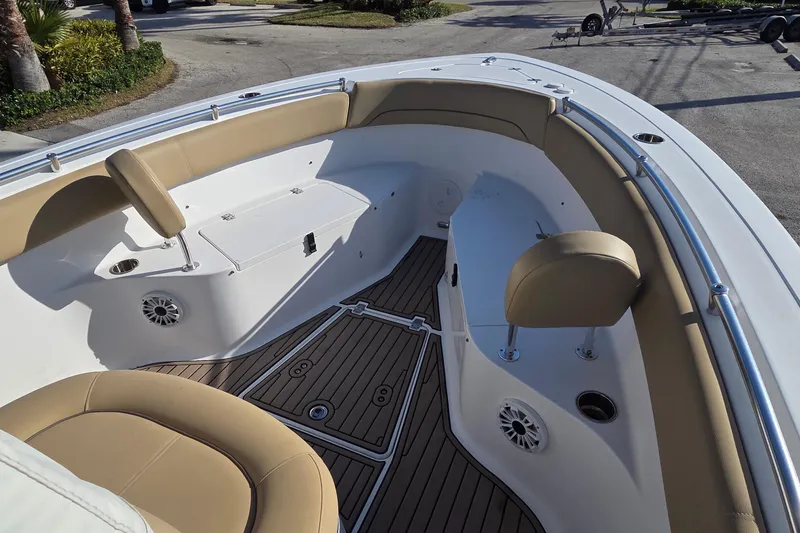 Slide: The Image of 2018 Sportsman Open 252 Center Console boat interior with tan seating and wood-style flooring. - 5