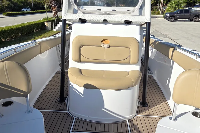 Slide: The Image of 2018 Sportsman Open 252 Center Console boat interior with tan seating and wood-style flooring. - 6