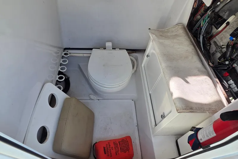 Slide: The Image of 2018 Sportsman Open 252 Center Console boat interior with toilet and storage. - 9
