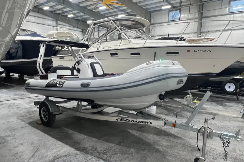 Slide: The Image of 2025 Highfield Velox 420 inflatable boat on trailer in indoor storage facility. - 5