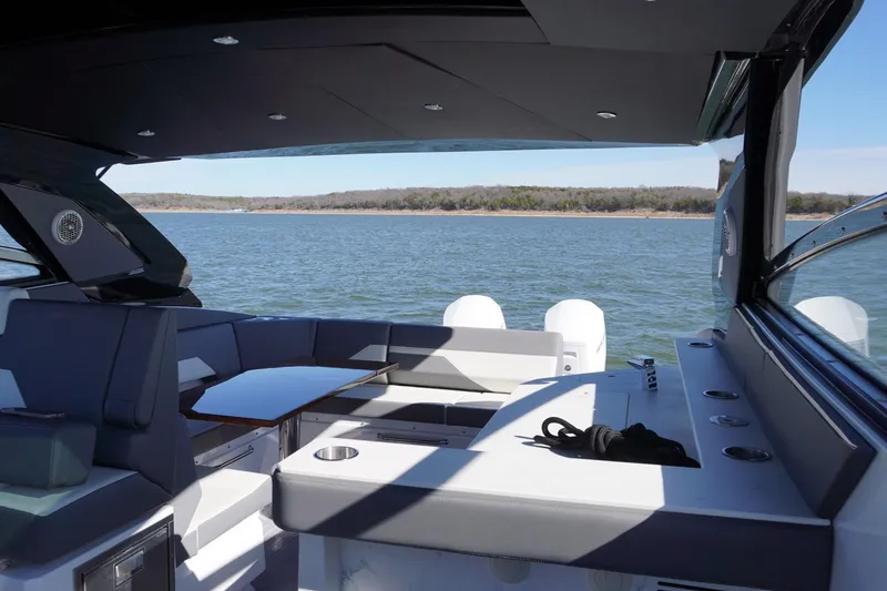 Slide: The Image of 2023 Cruisers Yachts 42 GLS OB interior with lake view, featuring seating and table. - 14