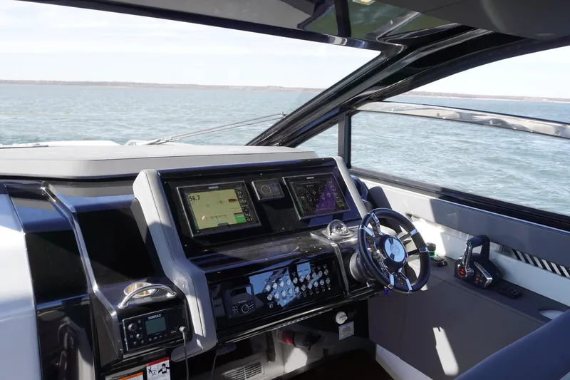 Slide: The Image of 2023 Cruisers Yachts 42 GLS OB helm with advanced navigation systems on open water. - 15