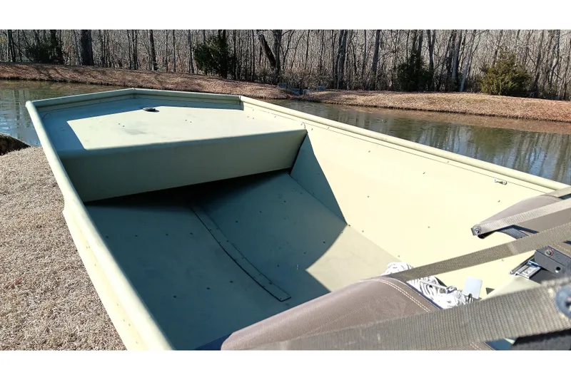 Slide: The Image of 2022 Lowe L1648M Jon boat on grassy shore by a pond, empty interior. - 10