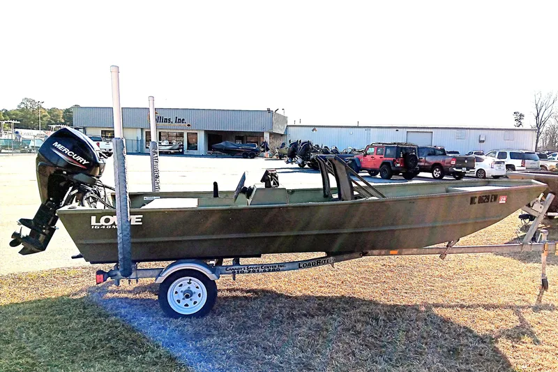 Slide: The Image of 2022 Lowe L1648M Jon boat on trailer with Mercury outboard motor, parked outdoors. - 6