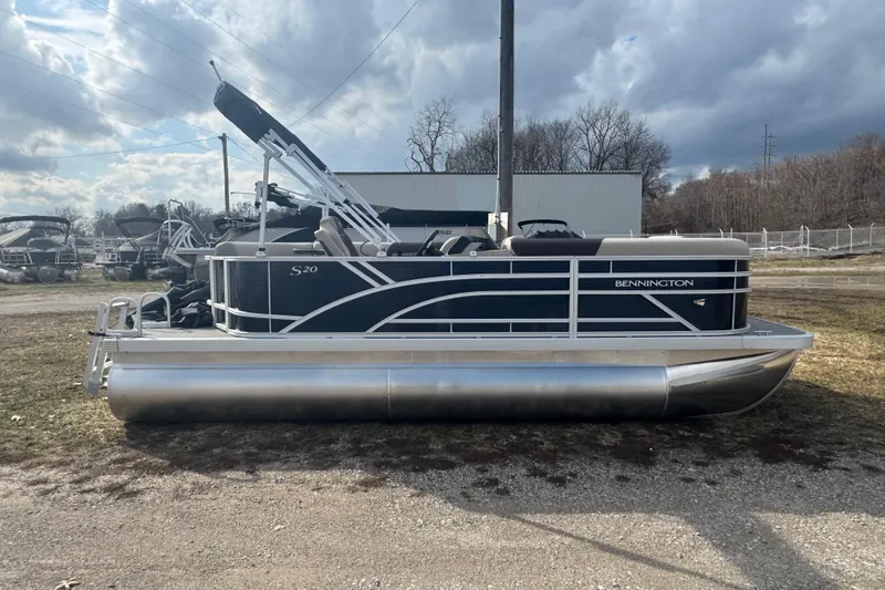 Slide: The Image of 2026 Bennington 20 SL pontoon boat parked outdoors under cloudy sky. - 3