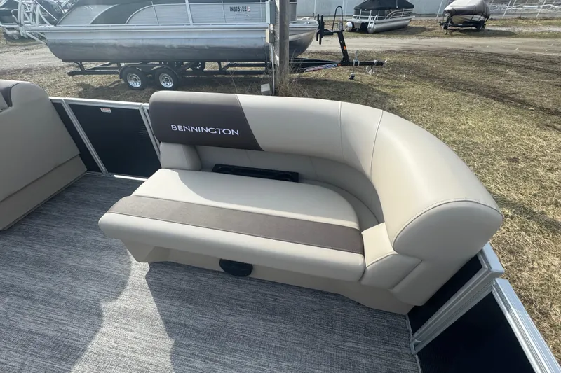 Slide: The Image of 2026 Bennington 20 SL boat interior with beige seating and logo. - 6