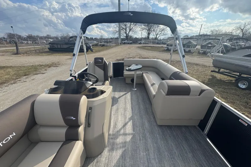 Slide: The Image of 2026 Bennington 20 SL pontoon boat with spacious seating and canopy under a cloudy sky. - 7