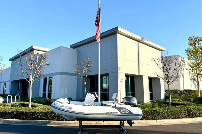 Slide: The Image of 2021 Walker Bay Generation 10 LTE boat on trailer outside modern building. - 1
